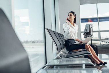 Sakin kadın uçuş beklerken telefonda konuşuyor