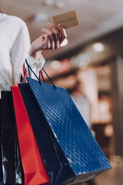 Señora está sosteniendo paquetes con compras mientras va en el centro comercial — Foto de Stock