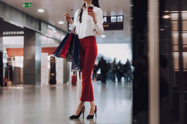 Elegante joven mujer está de compras en el aeropuerto — Foto de Stock