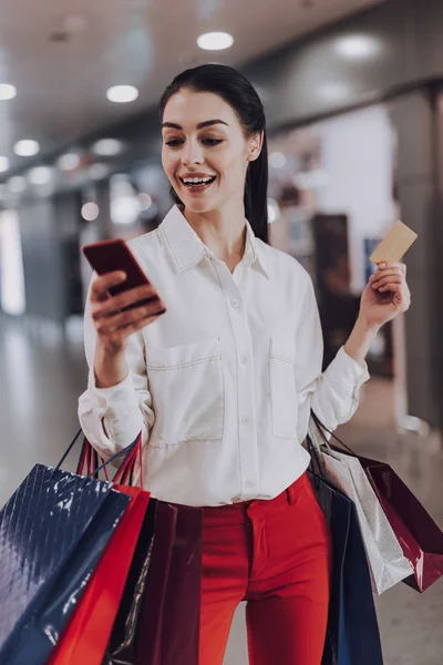 Jolly Woman med smartphone i köpcentrum — Stockfoto