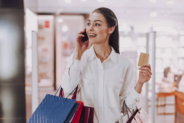 Feliz joven dama está hablando por teléfono mientras que las compras — Foto de Stock