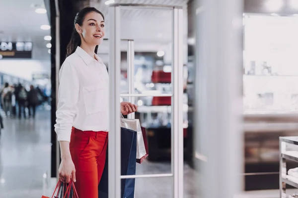 Mujer alegre viene a la tienda en el aeropuerto — Foto de Stock