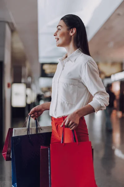 Señora alegre con compras a la espera de vuelo — Foto de Stock