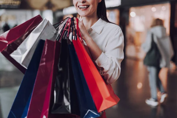 Mujer feliz sosteniendo bolsas con compras en el aeropuerto — Foto de Stock