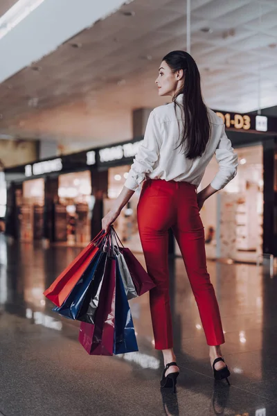 Trendfrau geht nach dem Einkauf mit Paketen ins Flugzeug — Stockfoto