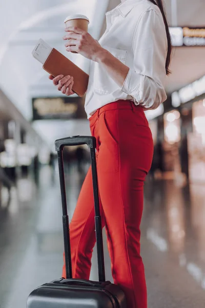 スーツケースを持った女性は、フライト前にコーヒーを飲んでいます — ストック写真