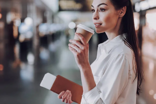 Спокойная женщина пьет кофе в аэропорту — стоковое фото