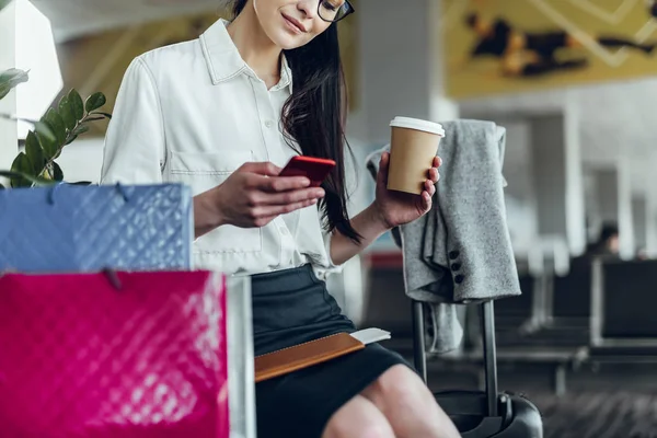 Mujer elegante está navegando por Internet mientras espera el vuelo —  Fotos de Stock