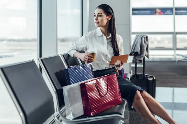 Jovencita se relaja con una taza de café en el aeropuerto —  Fotos de Stock