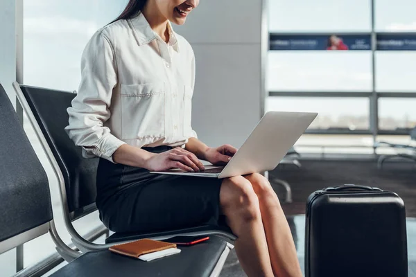 快乐的女人在飞行前使用笔记本电脑 — 图库照片