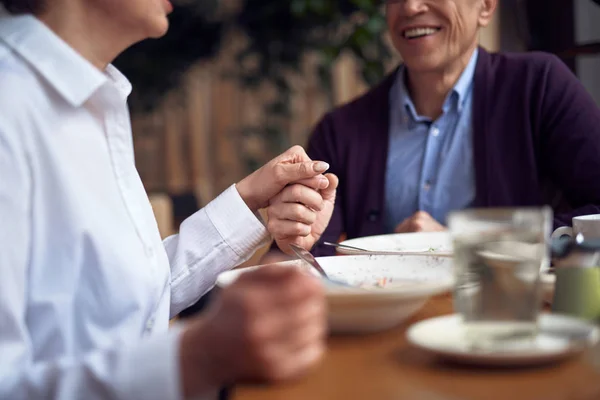 Man och kvinna håller händerna sittande i caféet — Stockfoto