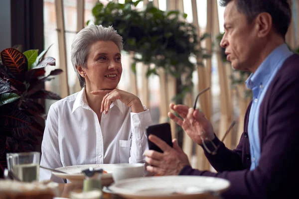 Aged woman listening male friend with interest — Stock Photo, Image