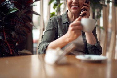 Kafede telefonla konuşan yaşlı kadını kapatın