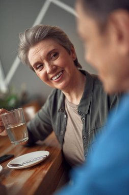Mutlu gülümseyen yaşlı kadın arkadaşına bakıyor