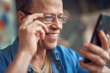 Gözlüklü Smilig adam cep telefonu smth okuyun