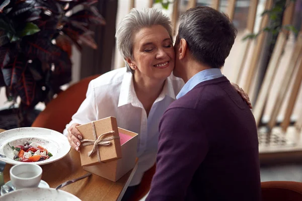 Happy woman gratefully kissing man for present — Stock Photo, Image