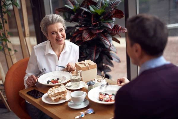 Envejecida mujer sonriente reunión con el hombre en la cafetería — Foto de Stock