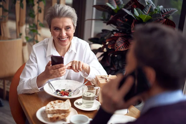优雅的微笑的女人在咖啡馆检查智能手机 — 图库照片