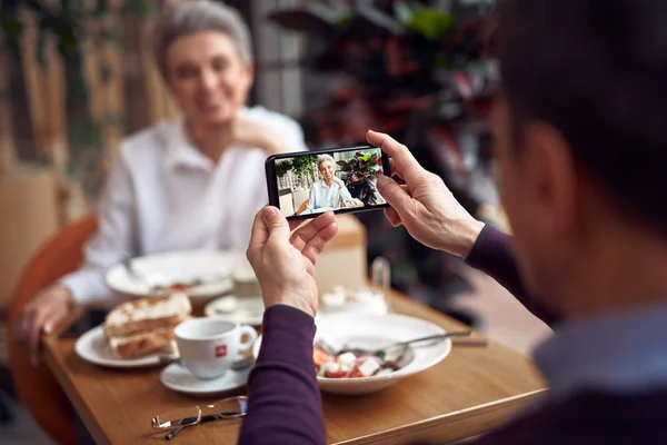 Man making photo of elegant lady on mobile phone — Stock Photo, Image