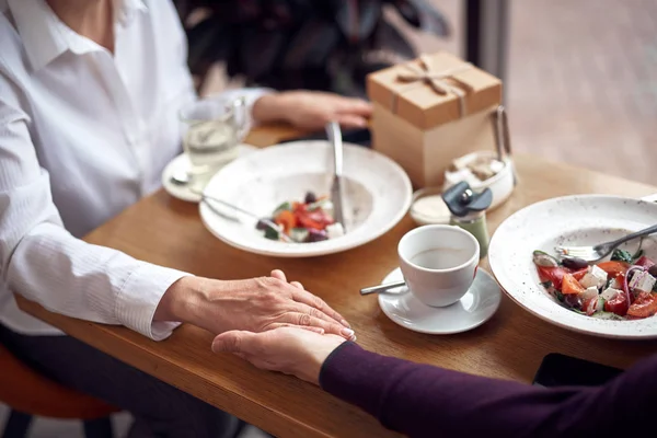 Close up male and female holding hands in cafe — Stock Photo, Image