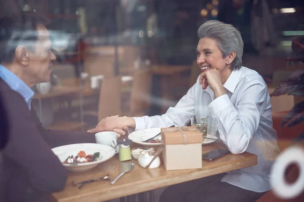 Щаслива елегантна літня пара насолоджується зустріччю в кафе — стокове фото