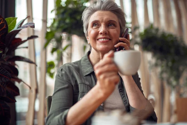 Feliz anciana hablando por teléfono móvil en la cafetería — Foto de Stock