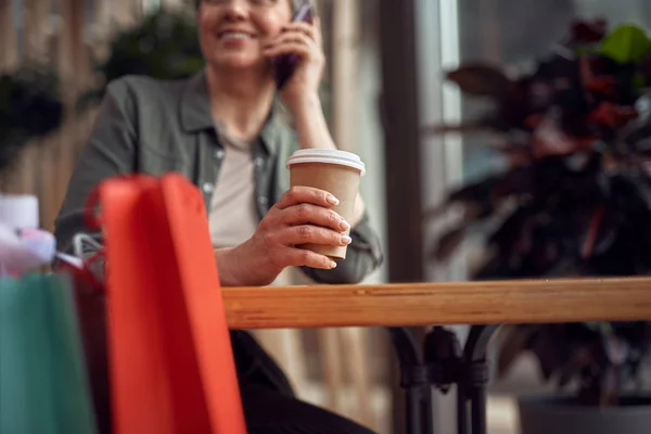Аккуратная стильная женщина разговаривает по телефону в кафе — стоковое фото