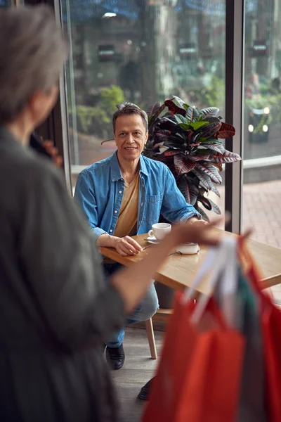 Homem sorridente envelhecido no café à espera de mulher — Fotografia de Stock