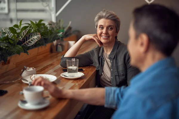 Happy smiling aged couple meeting in cafe