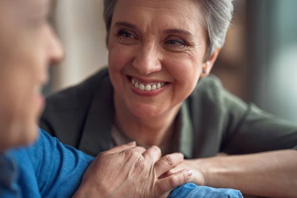 Cheerful aged lady looking with love to man