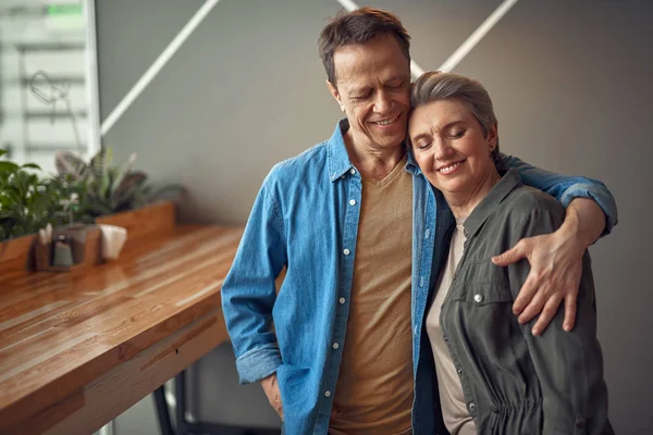 Feliz sonriente pareja de edad abrazando en la cafetería —  Fotos de Stock