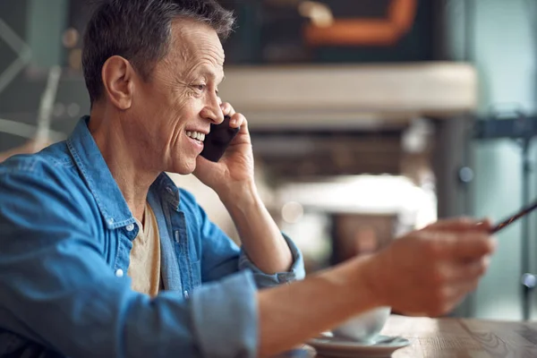 Happy mature man discussing by mobile phone — Stock Photo, Image