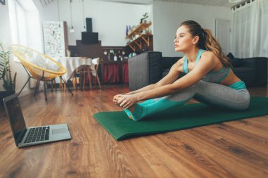 Paschimottanasana pozu vermeye çalışan genç bir kız.
