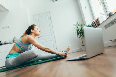Yoga pozu veren genç bir kadın.