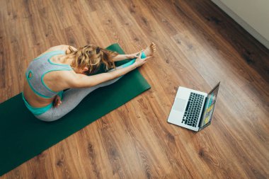 Kadın kafa-diz yogası pozu çalışıyor.