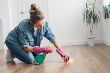 Evdeki zemini dikkatlice temizleyen kadın.