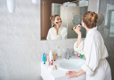 Gülümseyen bayan yanak üzerinde toz blusher döşeme