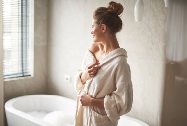 Banyo yapmaya hazır gülümseyen bayanın yan tarafı