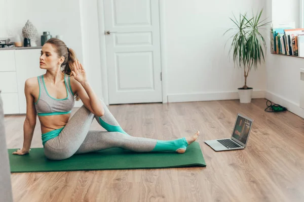 Balanced woman in ardha matsyendrasana yoga pose