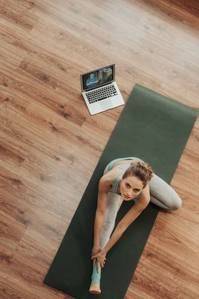 Mujer haciendo pose de yoga cabeza a rodilla —  Fotos de Stock