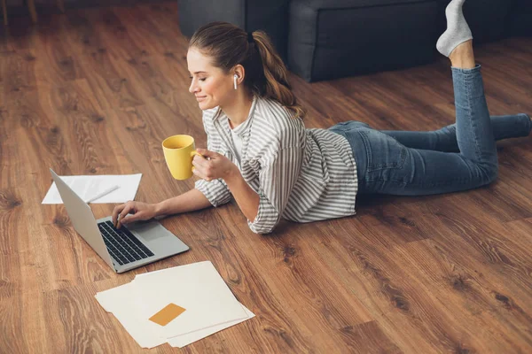 Sida på av kvinnliga arbetar på golvet med laptop — Stockfoto