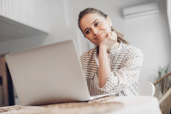 Glad kvinnlig chattar på laptop hemma — Stockfoto