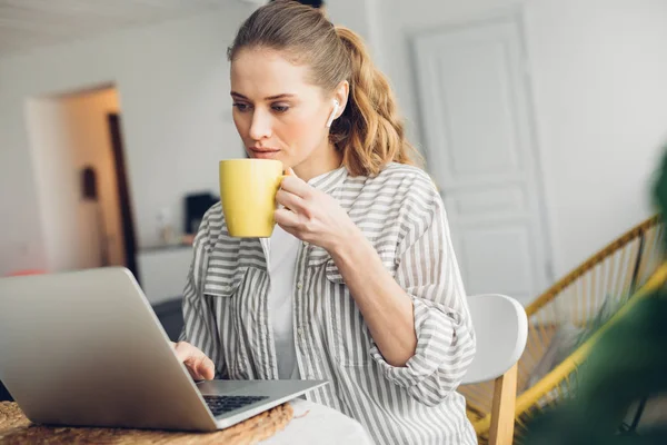 Mujer concentrada trabajando en la mesa con portátil — Foto de Stock