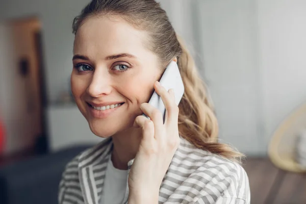 Jong glimlachende vrouw praten door mobiele telefoon — Stockfoto