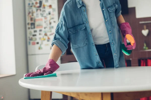 Joven mujer lavando mesa redonda en casa — Foto de Stock