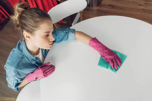 Mulher cansada de limpar a superfície da mesa em casa — Fotografia de Stock