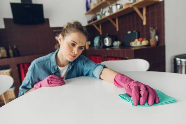 Mujer joven cansada de limpiar la mesa en casa — Foto de Stock