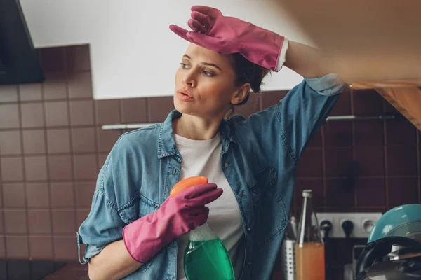 Уставшая женщина вытирает лоб после уборки — стоковое фото
