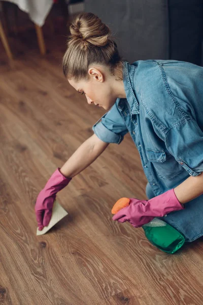 Mujer limpiando cuidadosamente la superficie del suelo en casa — Foto de Stock