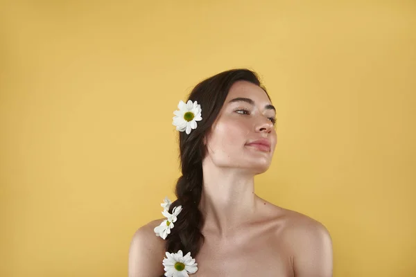 Portret van brunette vrouw met camomiles in haar — Stockfoto